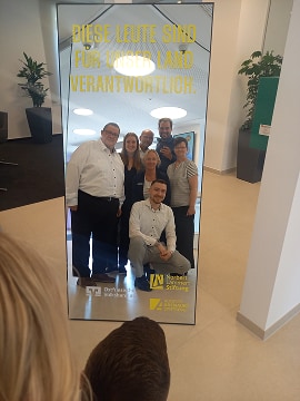 Kampagnenspiegel in einem Büro, davor sieben Personen